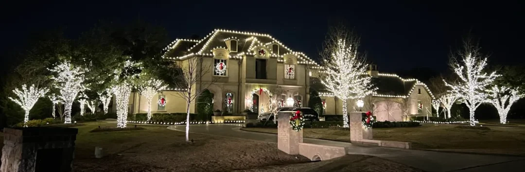 Elegant house decorated with bright Christmas lights and festive wreaths